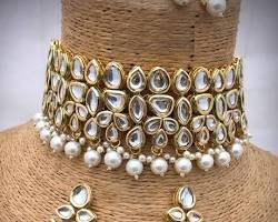 Kundan choker necklace set with pearl detailing displayed on a jewellery bust.