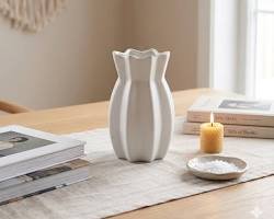 Minimalist white ceramic vase styled on a wooden table