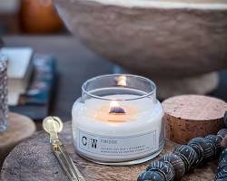 Minimalist glass candle with a wooden wick styled on a textured table