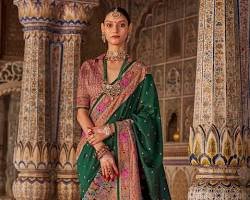 Woman wearing a traditional green silk saree with an ornate patterned border